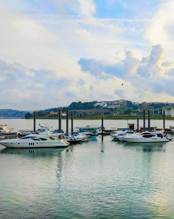 Sunset over marina with motorboats, Sao Joao bridge, golden cloudscape, Porto, Portugalの写真素材