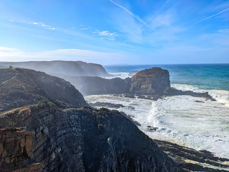 Seascape with Atlantic ocean rocky cliffs, bright sunshine, clear blue sky, Aljezur, Portugalの写真素材