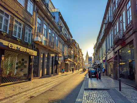 PORTO, PORTUGAL - JULY 20, 2022: Traditional tiled facade architecture of Trindade street in evening sunlight, church Santissima Trindade Igreja in background, Porto, Portugalのeditorial素材