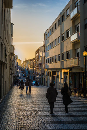 People walking down the street in Porto, Porugal at sunsetの写真素材