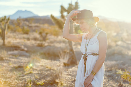 beautiful bohemian girl wearing fashion in desertの写真素材