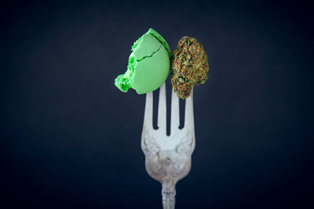 Marijuana Edibles On Vintage Silver Fork With Cannabis Buds. Selective Focus With Copy Space On Dark...