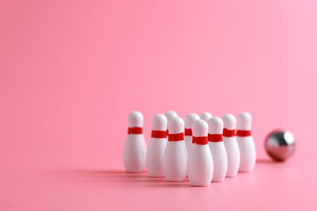 A wooden mini bowling game set and pins on pink backgroundの写真素材