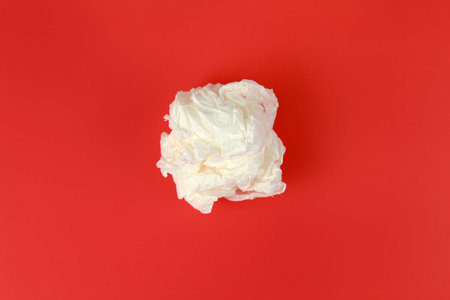 Crumpled white paper towel on a red background