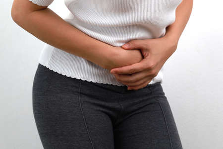 Midsection close up of woman feels strong stomach pain. People, healthcare and medicine concept.の写真素材