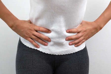 Midsection close up of woman feels strong stomach pain. People, healthcare and medicine concept.の写真素材