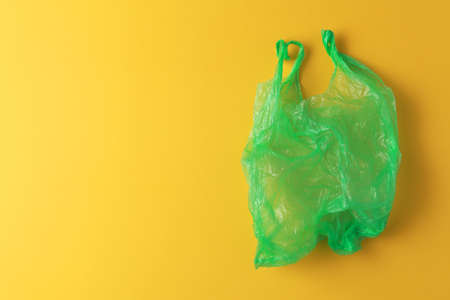 Green plastic bag on yellow background.の写真素材