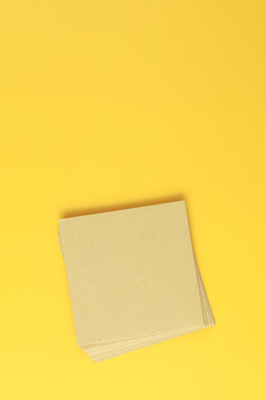 Stack of recycle brown papers on yellow background.