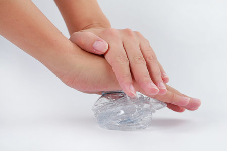 Cropped image of human hand crushed a plastic drinking bottle. Plastic drinking bottle trash waste...