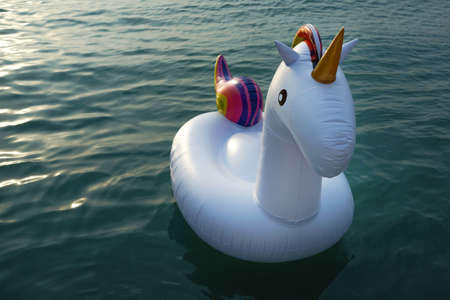 Inflatable plastic rubber unicorn floating on seawater.の写真素材