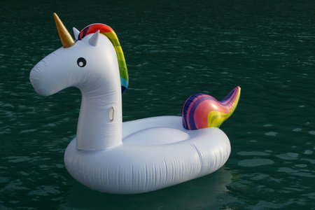 Inflatable plastic rubber unicorn floating on seawater.の写真素材
