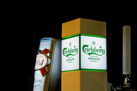 PENANG, MALAYSIA - 20 JAN 2022: View of Carlsberg and Kronenbourg 1664 Blanc beer tabs at the bar counter. Soft focus image.のeditorial素材