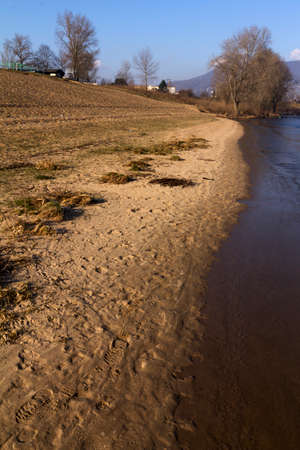 empty beach on the shore of the lake in winterの写真素材