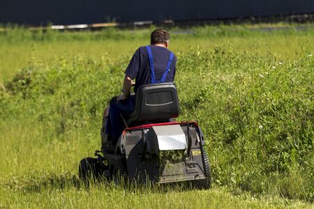 worker mows the lawn tractorの写真素材