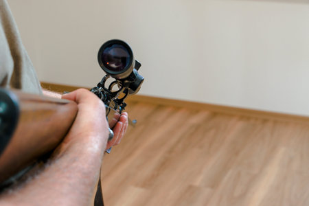 man is pointing his gun out of the windowの写真素材