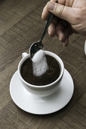 preparing hot coffee into a white mugの写真素材