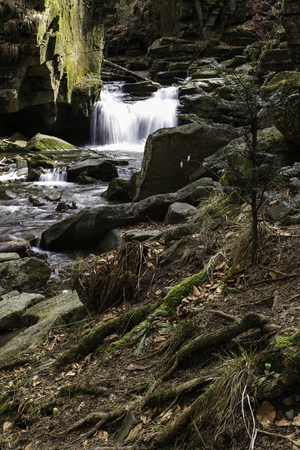 mountain waterfall among big stonesの写真素材