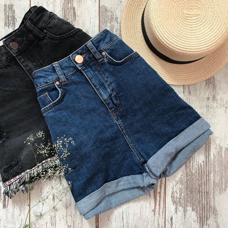 Female blue denim shorts on a wooden backgroundの写真素材