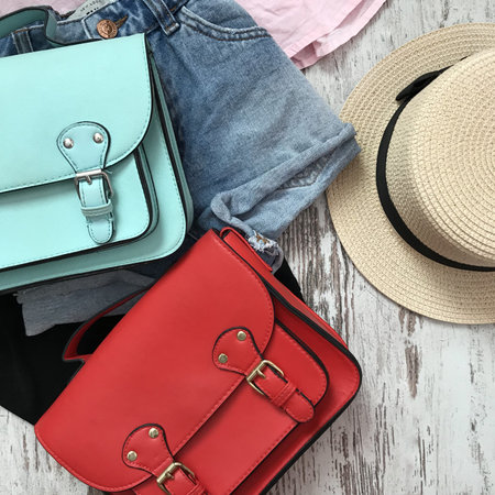 Red and turquoise handbags on a wooden table