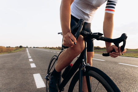 Professional road cyclist posing on camera with bike