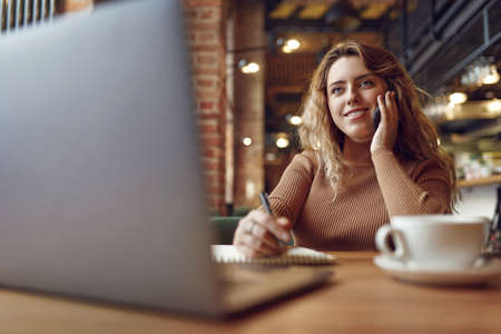 Pleasant woman having mobile conversation indoorsの写真素材
