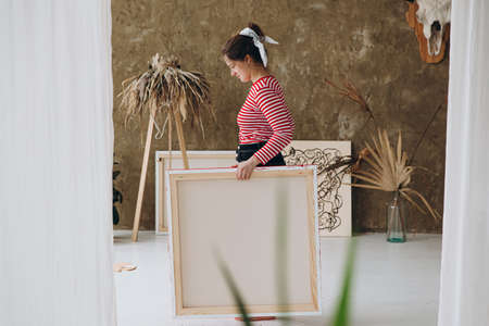 Side view of artist standing at art studio with canvasの写真素材