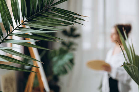 Blur background of female painter standing in front of easelの写真素材