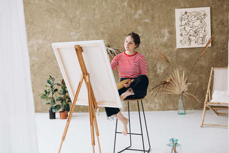 Beautiful woman using brush and color palette for paintingの写真素材