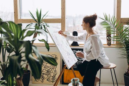Female artist drawing abstract picture on easelの写真素材