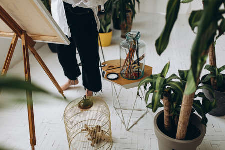 Close up of female artist with barefoot painting on canvasの写真素材
