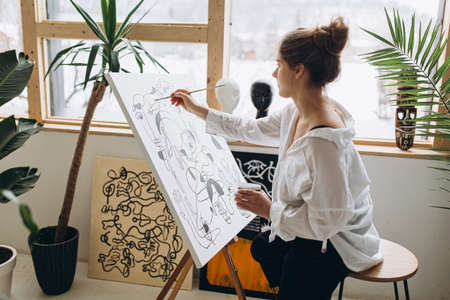 Pretty artist drawing black and white picture on canvasの写真素材