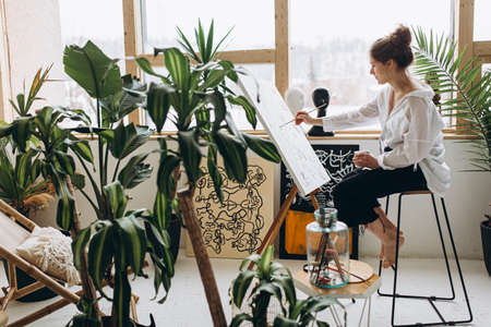 Side view of female artist painting on canvasの写真素材