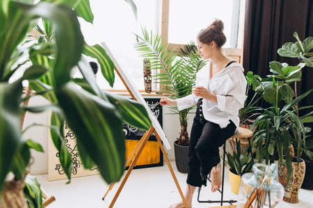 Artist painting on canvas with brush and color paletteの写真素材