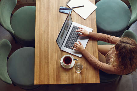 Female freelancer using laptop for work at cafeの写真素材