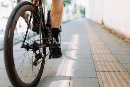 Male athlete in sport clothes and helmet posing with his professional bike on streets of old city. Caucasian man resting during active morning workout.の写真素材