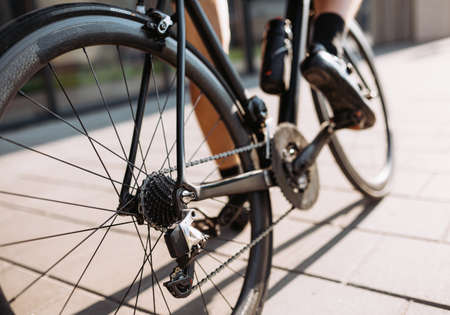 Caucasian male athlete taking break outdoors during morning cyclist. Positive young man sitting on bike and looking aside. Favorite sport hobby.の写真素材
