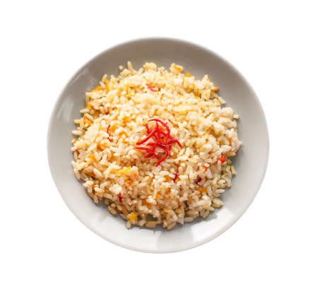 Spicy parboiled rice with carrots, yellow zucchini and chilli peppers on a gray plate. Isolated on white background with clipping pathの写真素材