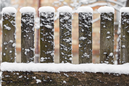 Wooden rural fence covered with snowの写真素材