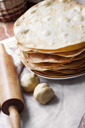 Cooking multi-layered cake Napoleon - baked cake layers, raw dough and wooden rolling pinの写真素材