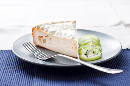 Homemade cottage cheese and semolina cake with kiwi fruit and cream on a plateの写真素材