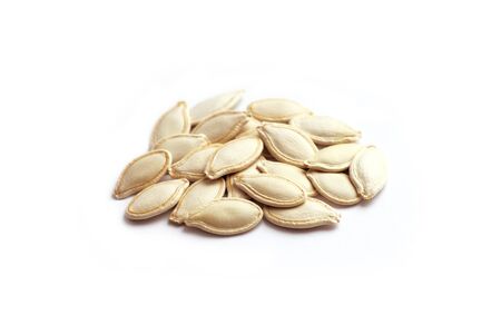Heap of shelled, pumpkin seeds isolated on white backgroundの写真素材