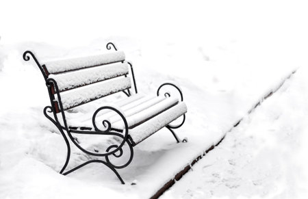 Winter has come. Single empty bench covered with snow in a winter park. Copy spaceの写真素材
