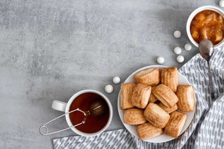 Tasty breakfast. Homemade sweet cinnamon cookies, cup of tea and apple confiture. Flatlay, top view, copy spaceの写真素材