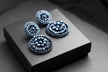 Deep blue seed beads embroidered statement earrings on black backgroundの写真素材