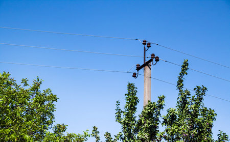 Electric support pole with ceramic elements against blue sky backgroundの写真素材