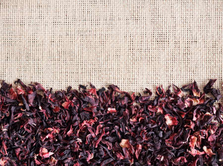 Straw mat background with dry hibiscus tea, closeup. Flat lay, top view.の写真素材