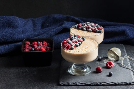 Ryazhenka (fermented baked milk) mousse in glass bowls decorated with fresh berries