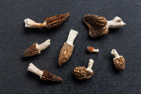 Morel mushrooms closeup on black background. Flatlay