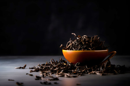 Dry black tea in ceramic bowl on dark background with copy space. AI generated.の素材