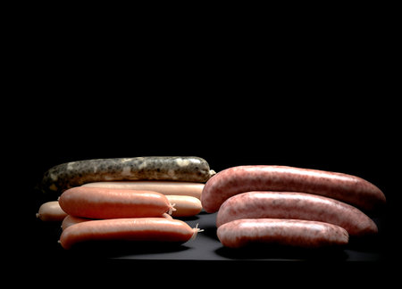 Assorted raw homemade sausages on black background with copy spaceの素材
